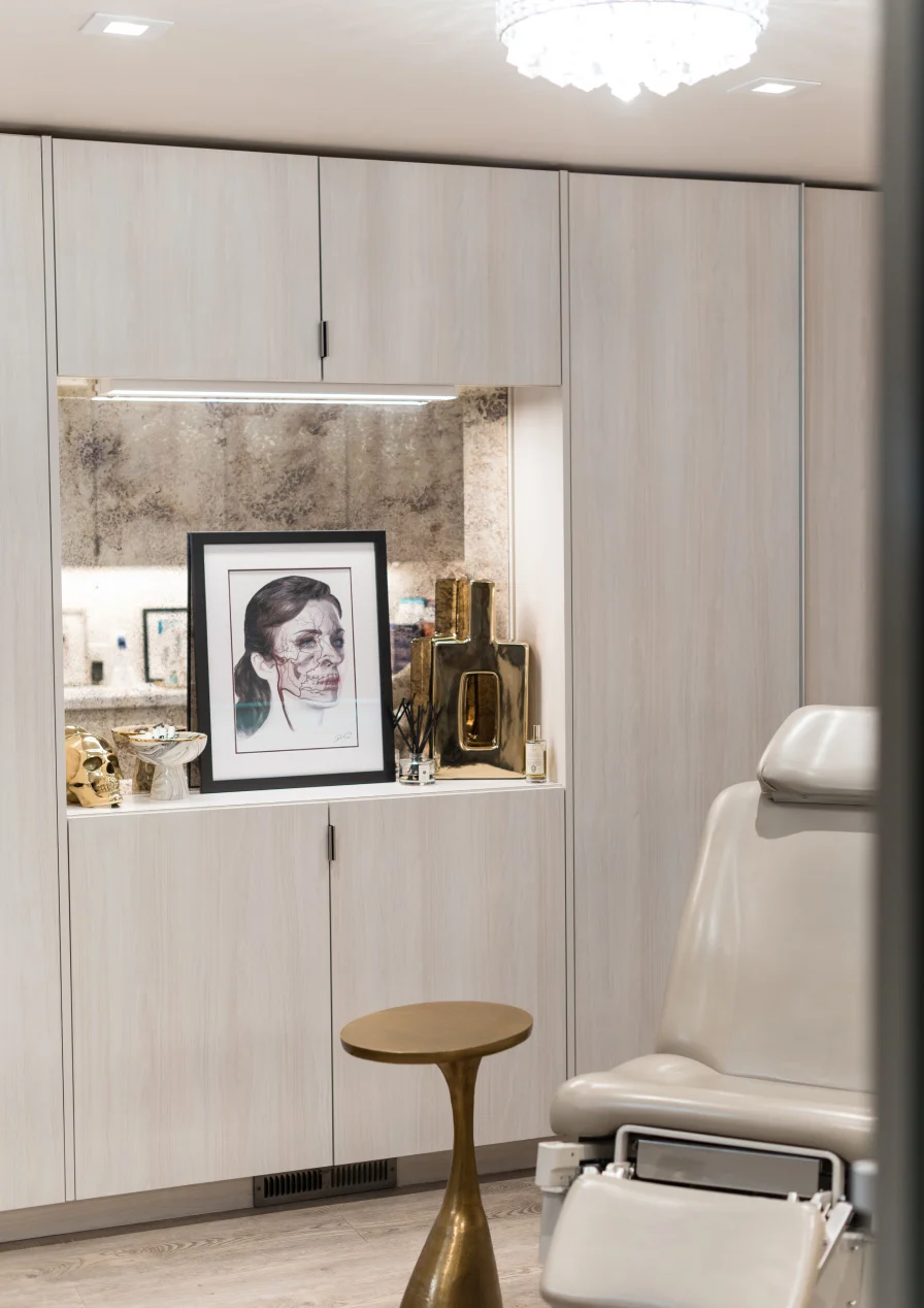 Modern home entryway with built-in storage cabinets, decorative niche, vintage portrait, and gold accent table