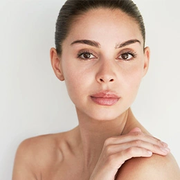 Natural beauty portrait of woman with glowing skin and elegant hand pose on white background
