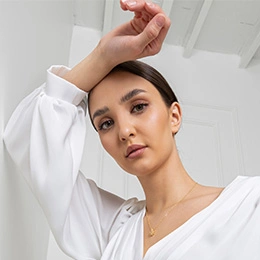 Woman in white oversized shirt with elegant minimalist style and natural makeup looking at camera