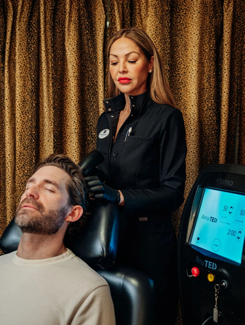 Professional administering Biologique Recherche facial treatment to male client with medical device in luxury spa setting - TED Hair Restoration in Bend, OR